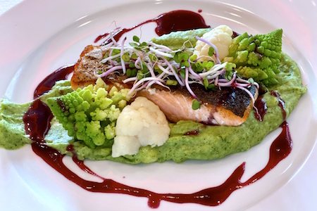 Grilled salmon with potato-spinach puree, stewed vegetables and wine reduction